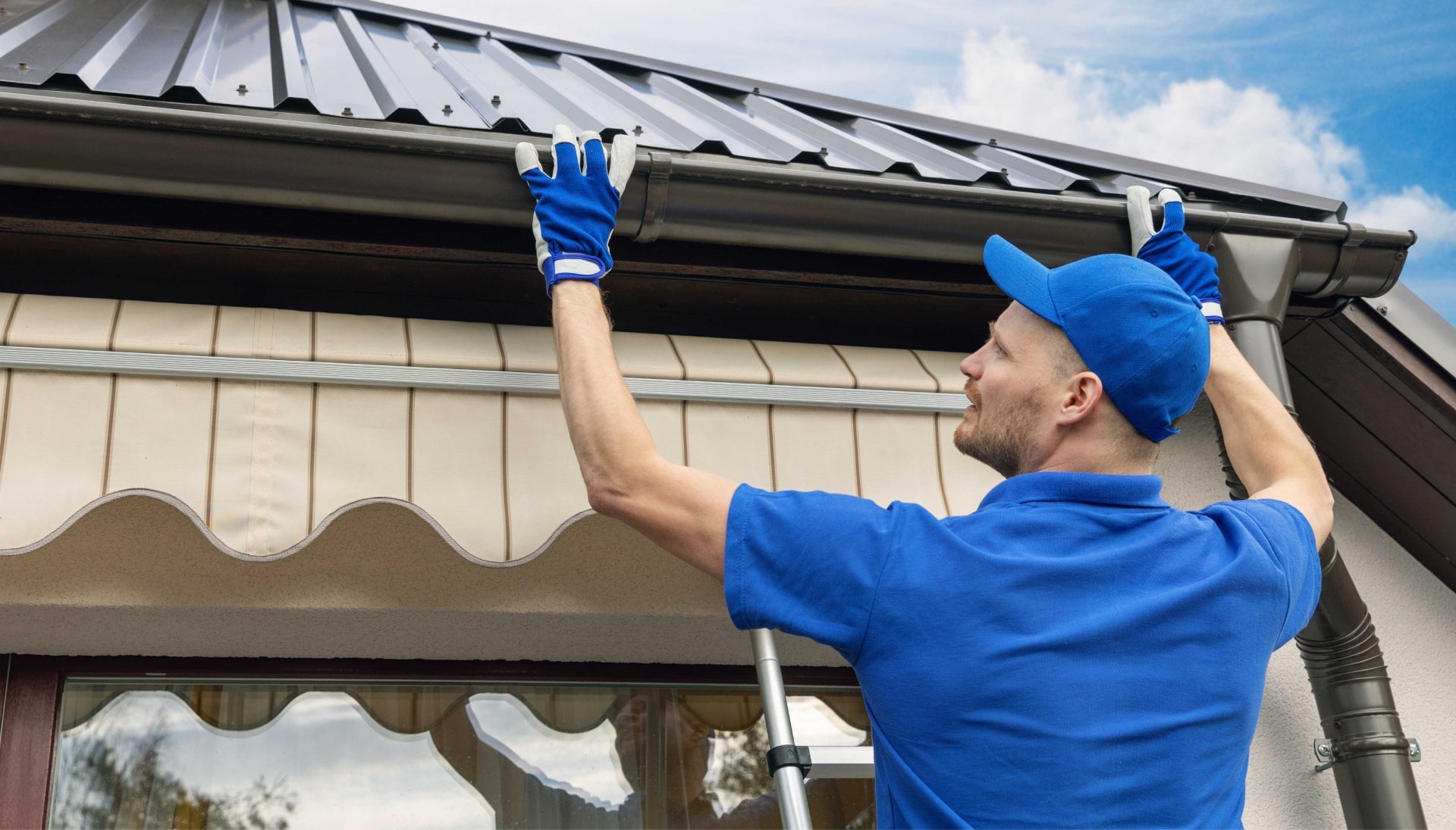 A gutter installer measuring and cutting gutters to the proper length in Lafayette, LA